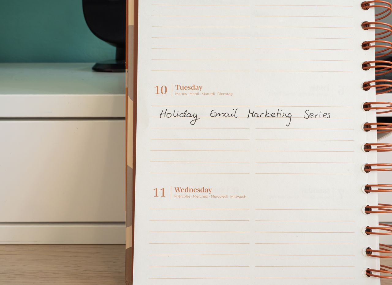 services-03 Planner open on a desk with handwritten Holiday Email Marketing Series note.